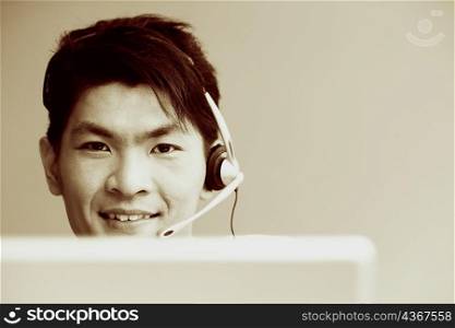 Portrait of a male customer service representative talking on a headset and smiling