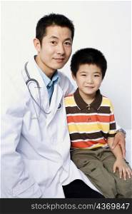 Portrait of a male doctor and a boy sitting together