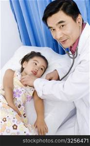 Portrait of a male doctor examining a girl