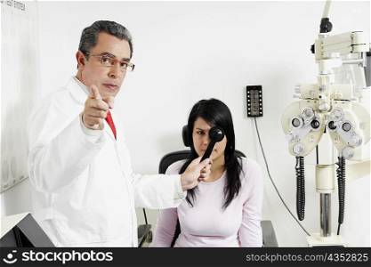 Portrait of a male doctor examining a young woman&acute;s eye