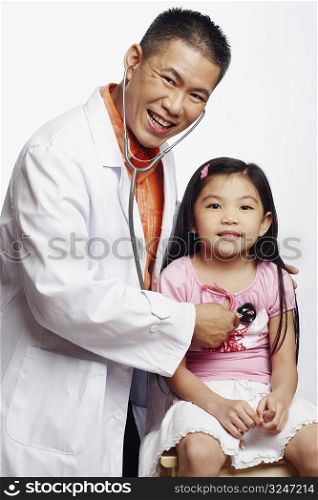 Portrait of a male doctor examining his patient with a stethoscope