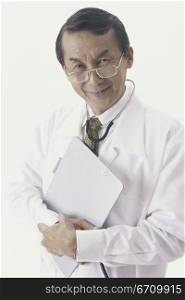 Portrait of a male doctor holding a clipboard smiling