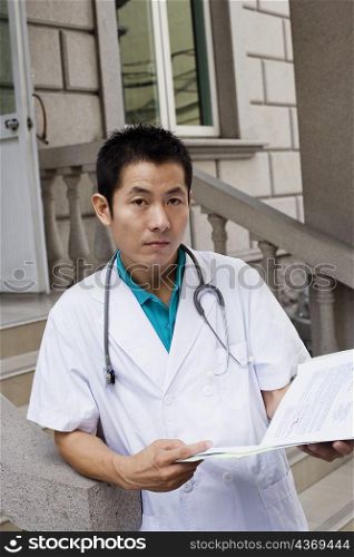 Portrait of a male doctor holding a report