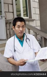 Portrait of a male doctor holding a report