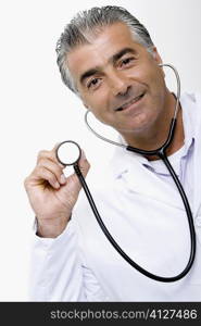 Portrait of a male doctor holding a stethoscope and smiling