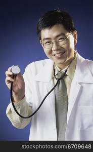 Portrait of a male doctor holding a stethoscope smiling