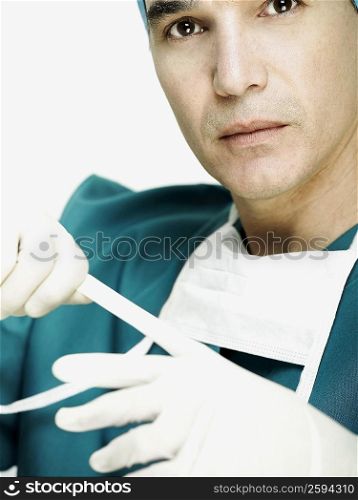 Portrait of a male doctor removing his gloves