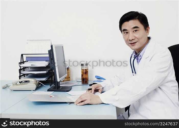 Portrait of a male doctor sitting at the table