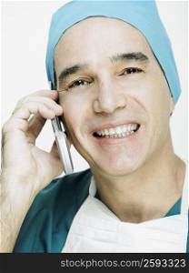 Portrait of a male doctor smiling and talking on a mobile phone