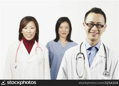 Portrait of a male doctor with a female doctor and a female nurse standing behind him