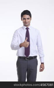 Portrait of a male executive giving thumbs up