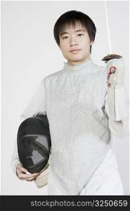 Portrait of a male fencer holding a fencing foil and a fencing mask