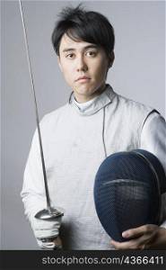 Portrait of a male fencer holding a sword and a fencing mask