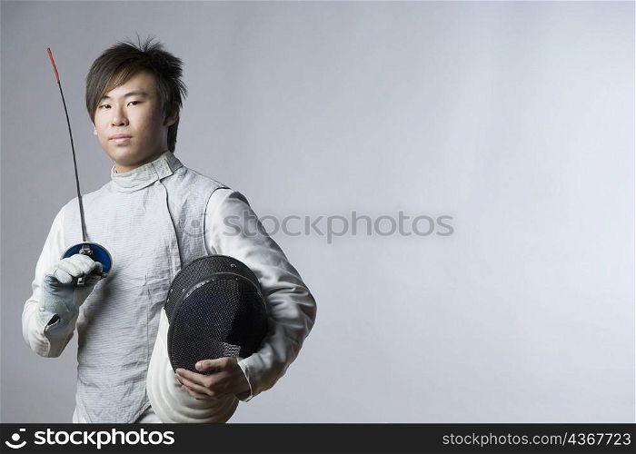 Portrait of a male fencer holding a sword and a fencing mask