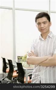 Portrait of a male office worker standing with his arms crossed
