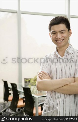 Portrait of a male office worker standing with his arms crossed and smiling