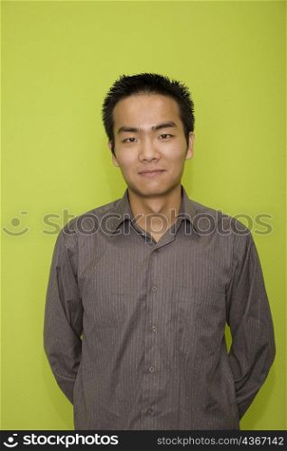 Portrait of a male office worker standing with his hands behind his back