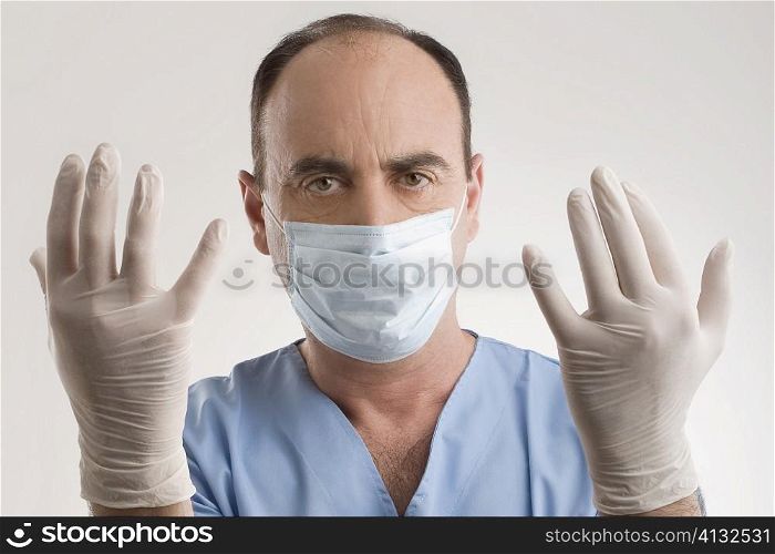 Portrait of a male surgeon wearing surgical glove and surgical mask
