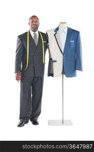 Portrait of a male tailor standing next to a mannequin