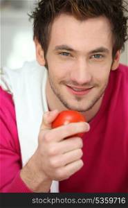 Portrait of a man holding a tomato