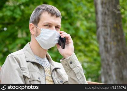 Portrait of a man in a medical mask talking on the phone