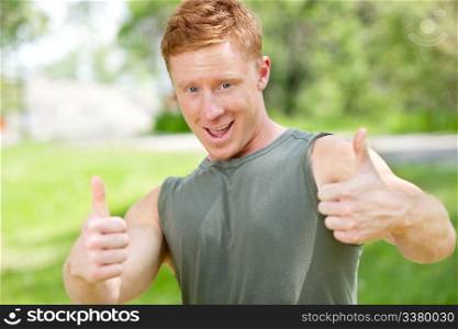 Portrait of a man showing thumbs-up sign against blur background