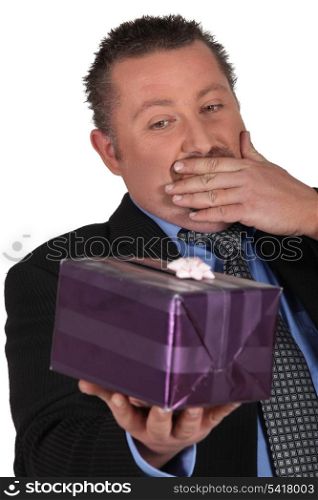 Portrait of a man surprised in front of a gift package