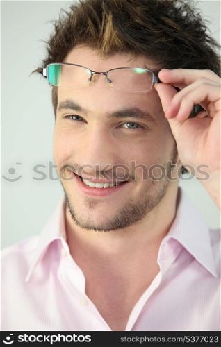 Portrait of a man taking his glasses off