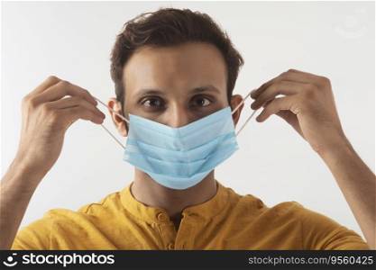 Portrait of a man taking precautions by covering his face with a mask