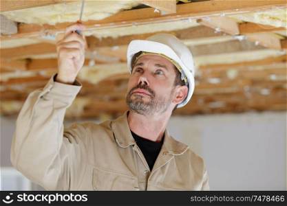 portrait of a man working on ceiling
