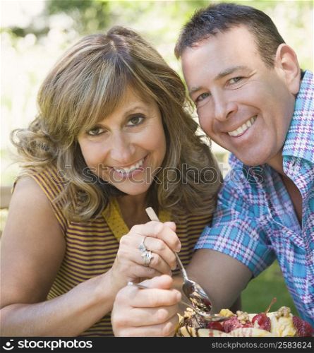 Portrait of a mature couple eating fruit salad and smiling