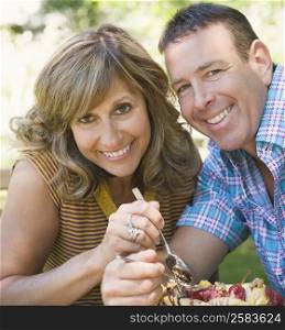 Portrait of a mature couple eating fruit salad and smiling