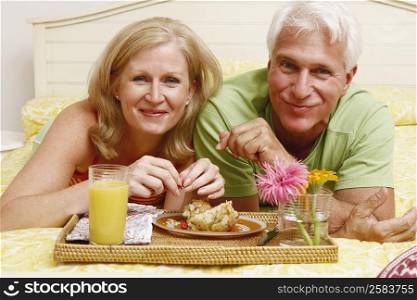 Portrait of a mature couple having breakfast in bed