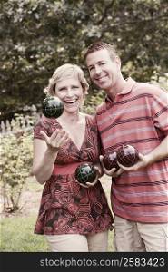 Portrait of a mature couple holding balls and smiling