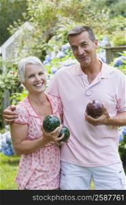 Portrait of a mature couple holding bocce balls and smiling