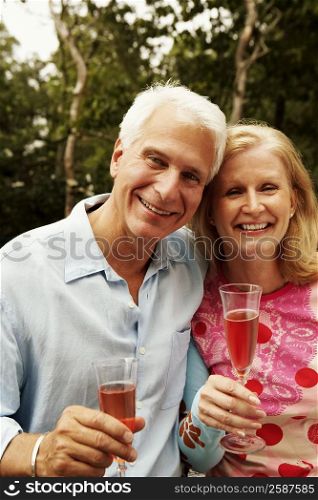 Portrait of a mature couple holding champagne flutes and smiling