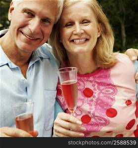 Portrait of a mature couple holding champagne flutes and smiling
