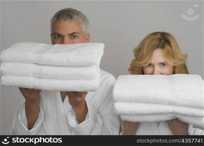 Portrait of a mature couple holding folded towels