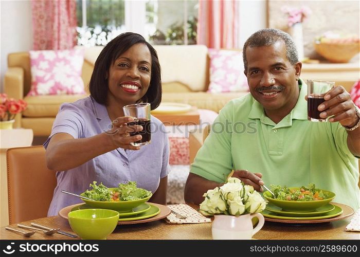 Portrait of a mature couple holding glasses of drink and smiling