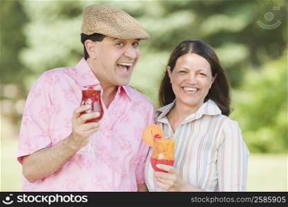 Portrait of a mature couple holding glasses of juice and smiling