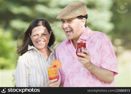 Portrait of a mature couple holding glasses of juice and smiling