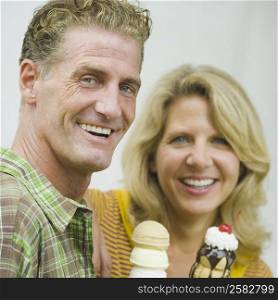 Portrait of a mature couple holding ice cream cones and smiling