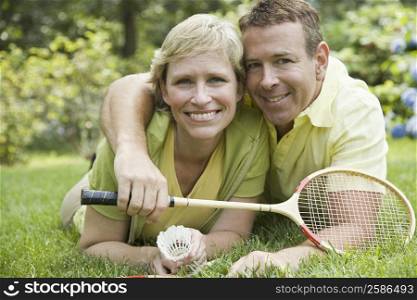 Portrait of a mature couple lying in a lawn and smiling