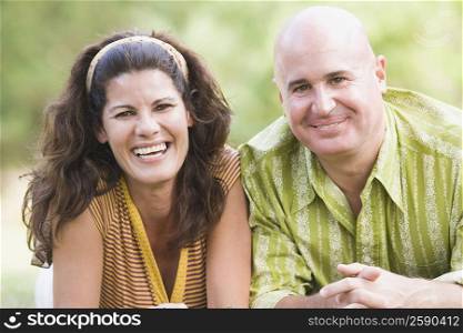 Portrait of a mature couple lying on grass and smiling