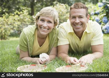 Portrait of a mature couple lying on grass in a lawn