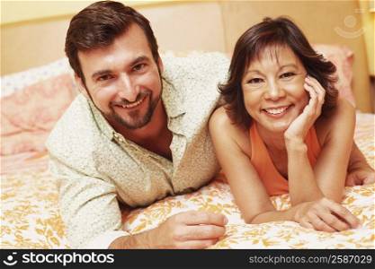 Portrait of a mature couple lying on the bed and smiling