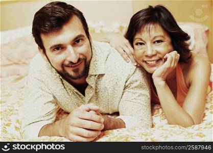 Portrait of a mature couple lying on the bed and smiling