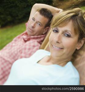 Portrait of a mature couple reclining on chairs and smiling