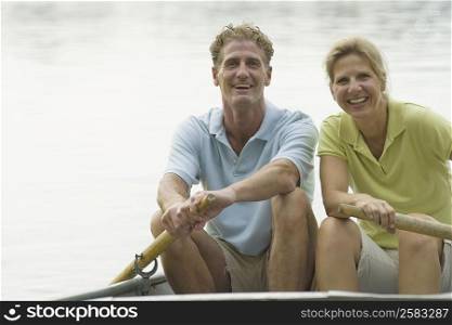 Portrait of a mature couple rowing a boat and smiling