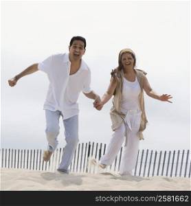 Portrait of a mature couple running on the beach
